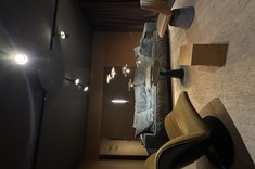 Strefa wypoczynkowa w showroomie Metaforma Design. Fotele w różnych odcieniach miodowych, a obok duża, pluszowa sofa w eleganckich tonacjach szarości i turkusu, tworząca stylową i przytulną przestrzeń do relaksu